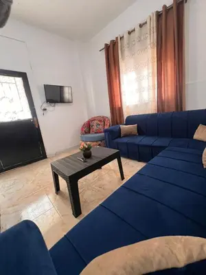 a living room with a blue couch and a table at دار زمان Zaman Suites Old Town in Al Mafraq