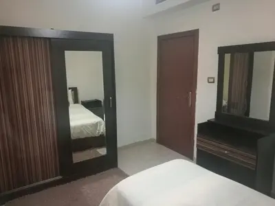 a bedroom with a mirror and a bed and a dresser at Apartment in Abdoun Al Janobi in Amman