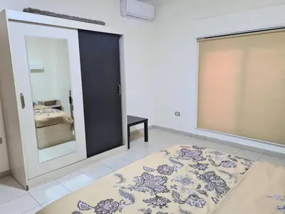 a bedroom with a mirror and a bed and a rug at Apartment in Abdoun Al Janobi in Amman