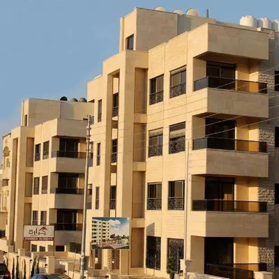 a tall building with a sign in front of it at Apartment in Abdoun Al Janobi in Amman