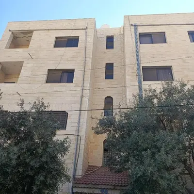 a large brick building with trees in front of it at Bourbaki house