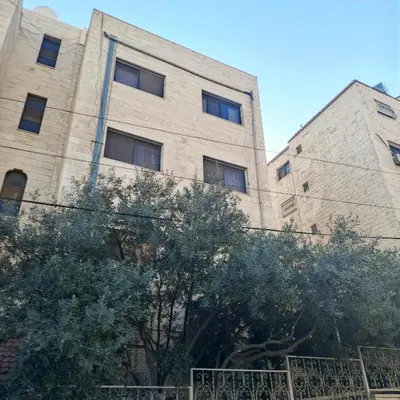 a large brick building with trees in front of it at Bourbaki house