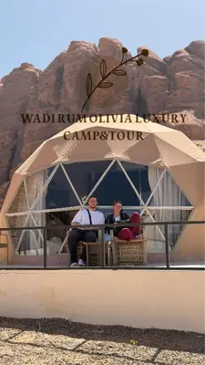 two people sitting on a boat in the desert at WADI RUM OLIVIA lUXURY CAMP & TOUR in Wadi Rum