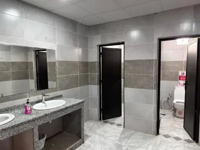 a bathroom with two sinks and a mirror and a toilet at WADI RUM OLIVIA lUXURY CAMP & TOUR in Wadi Rum