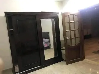 a room with a wooden door and a mirror at المناخير هوستل in Amman