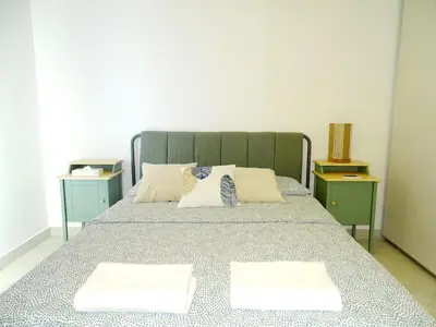 a bedroom with a bed with two night stands at B12 beach apartment Ayla in Al Jafr