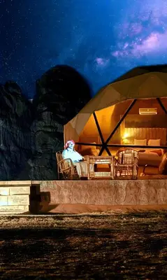 a person sitting in a tent at night at Luxury diamond camp in Wadi Rum