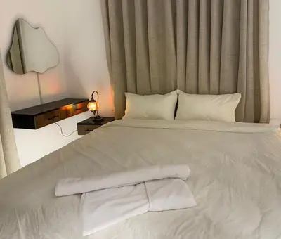 a white bed with white sheets and pillows at Beit Ahlan Suites 7 in Amman