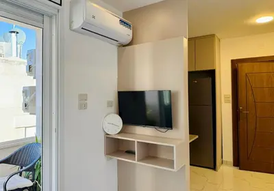 a living room with a tv on a wall at Beit Ahlan Suites 7 in Amman