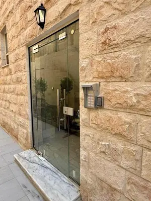 a glass door on the side of a stone building at Beit Ahlan Suites 8 in Amman