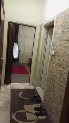 a view of a hallway with shoes on the floor at 10 seasoun House in Dawqarah