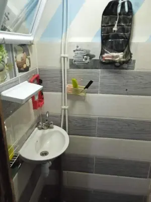 a small bathroom with a sink and a backpack at 10 seasoun House in Dawqarah