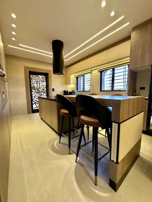 a kitchen with a bar with stools in it at Modern Residence for families only in Amman