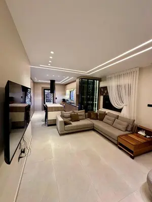 a large living room with a couch and a television at Modern Residence for families only in Amman