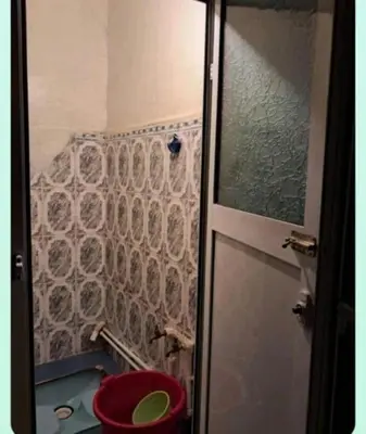 a bathroom with a shower and a red toilet at mraco apartment in Amman