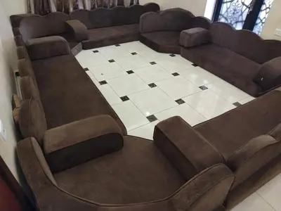 a waiting room with brown chairs and a checkered floor at mraco apartment in Amman