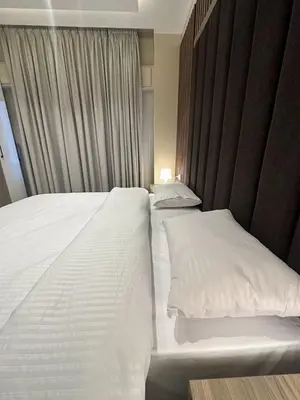 a bedroom with two beds with white pillows at Charming Amman Apartment with Modern furnis in Amman
