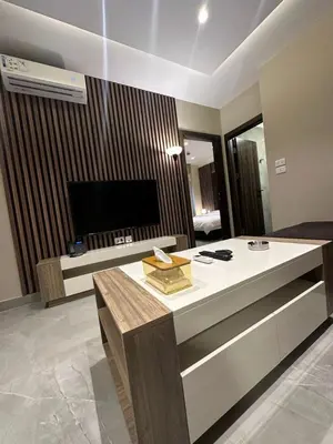 a living room with a table and a television at Charming Amman Apartment with Modern furnis in Amman