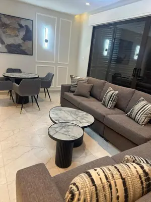 a living room with a couch and tables and chairs at Apartment in dergbar in Amman