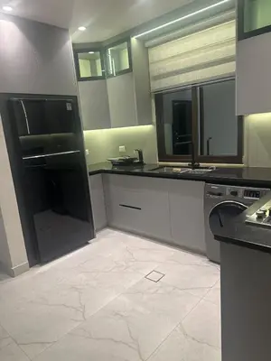 a kitchen with black and white counters and mirrors at Apartment in dergbar in Amman
