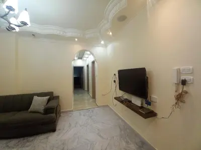 a living room with a couch and a flat screen tv at Amman Central Elegant Apartment in Amman