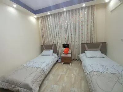 a room with two beds and a teddy bear in it at Amman Central Elegant Apartment in Amman