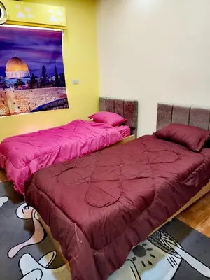 two beds sitting next to each other in a bedroom at A large, fully furnished Apartment in Amman