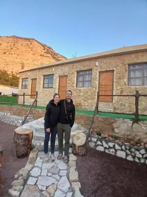 a man and woman standing in front of a building at Friends of Dana Hotel in Dana