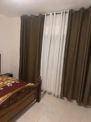 a bedroom with green and white curtains and a bed at الاردن عمان الجاردنز in Amman