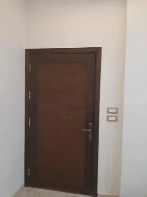 a wooden door in a room with a wall at العنبق هاوس