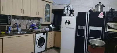 a kitchen with a refrigerator and a washer and dryer at العنبق هاوس