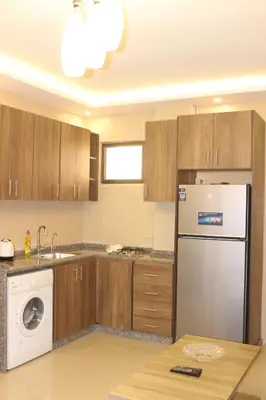 a kitchen with a washer and a white refrigerator at Private Studio in Amman