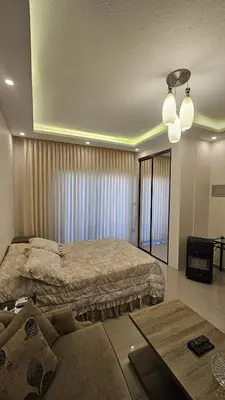 a bedroom with a large bed and a couch at Private Studio in Amman