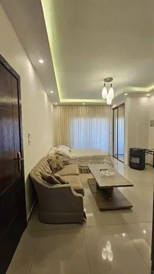 a bedroom with a bed and a couch and a table at Private Studio in Amman