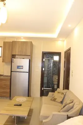 a kitchen with a couch and a refrigerator and a table at Private Studio in Amman