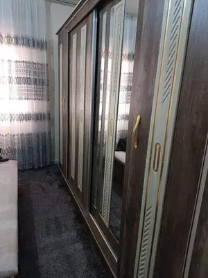 a wooden door in a room with a mirror at kazami House in At-Tafilah