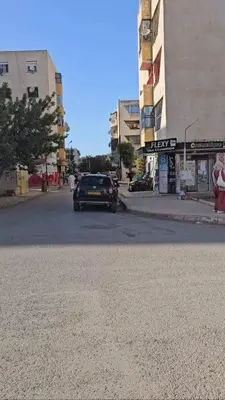 a car is driving down a city street at Zomik house in Al Qiḩāţī