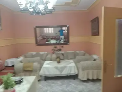 a living room with a table and a mirror at Zomik house in Al Qiḩāţī
