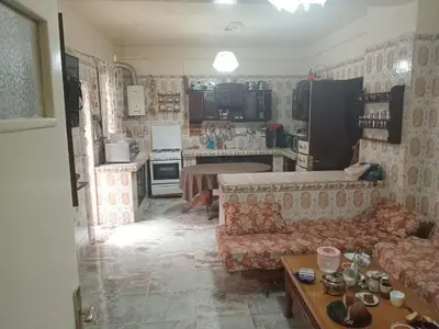 a living room with a couch and a kitchen at Zomik house in Al Qiḩāţī