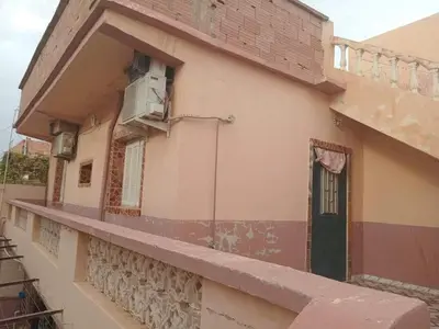 a building with a balcony with a door and a window at Zomik house in Al Qiḩāţī