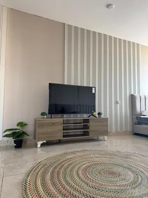 a living room with a large flat screen tv at sky view rooftop in Amman