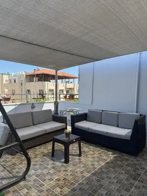 a living room with two couches and a table at sky view rooftop in Amman