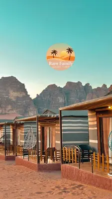 a row of resorts with tables and chairs in front of a mountain at RUM fAMILY lUXURY CAMP in Wadi Rum