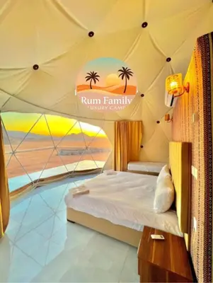 a bed in a tent with a view of the ocean at RUM fAMILY lUXURY CAMP in Wadi Rum