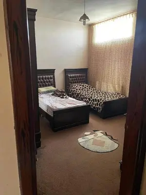 a room with two beds and a window at Nargges House in Al Salt