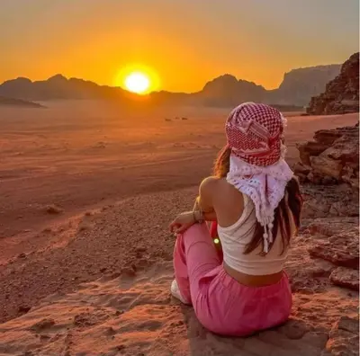a girl sitting on the beach watching the sunset at saleem with jeep tour in Wadi Rum