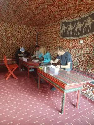 a group of people sitting at tables in a room at saleem with jeep tour in Wadi Rum