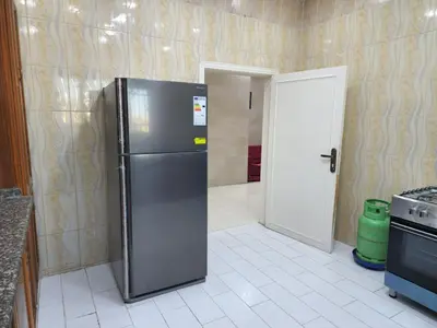 a kitchen with a stainless steel refrigerator in a room at Monani in Amman