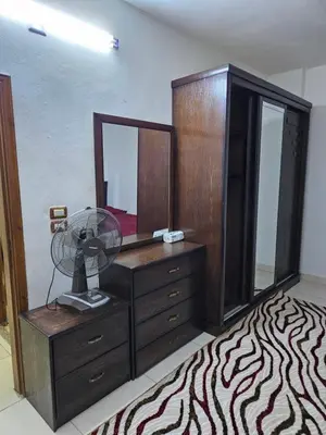 a bedroom with a dresser with a fan and a mirror at غصن الزيتون in Ajloun