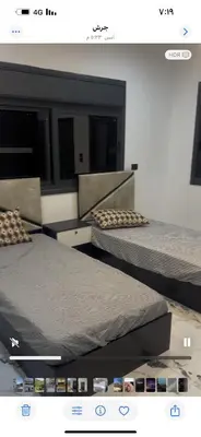 two beds in a room with avertisement at فيلا مفروشه ومزرعه للايجار in Jerash